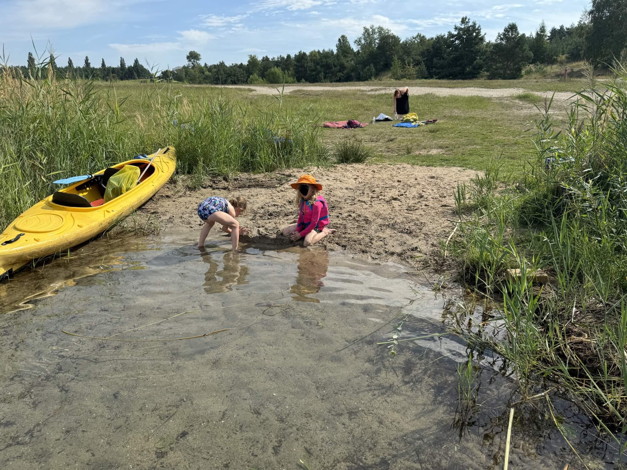 zwei Kinder spielen am Ufer eines Sees