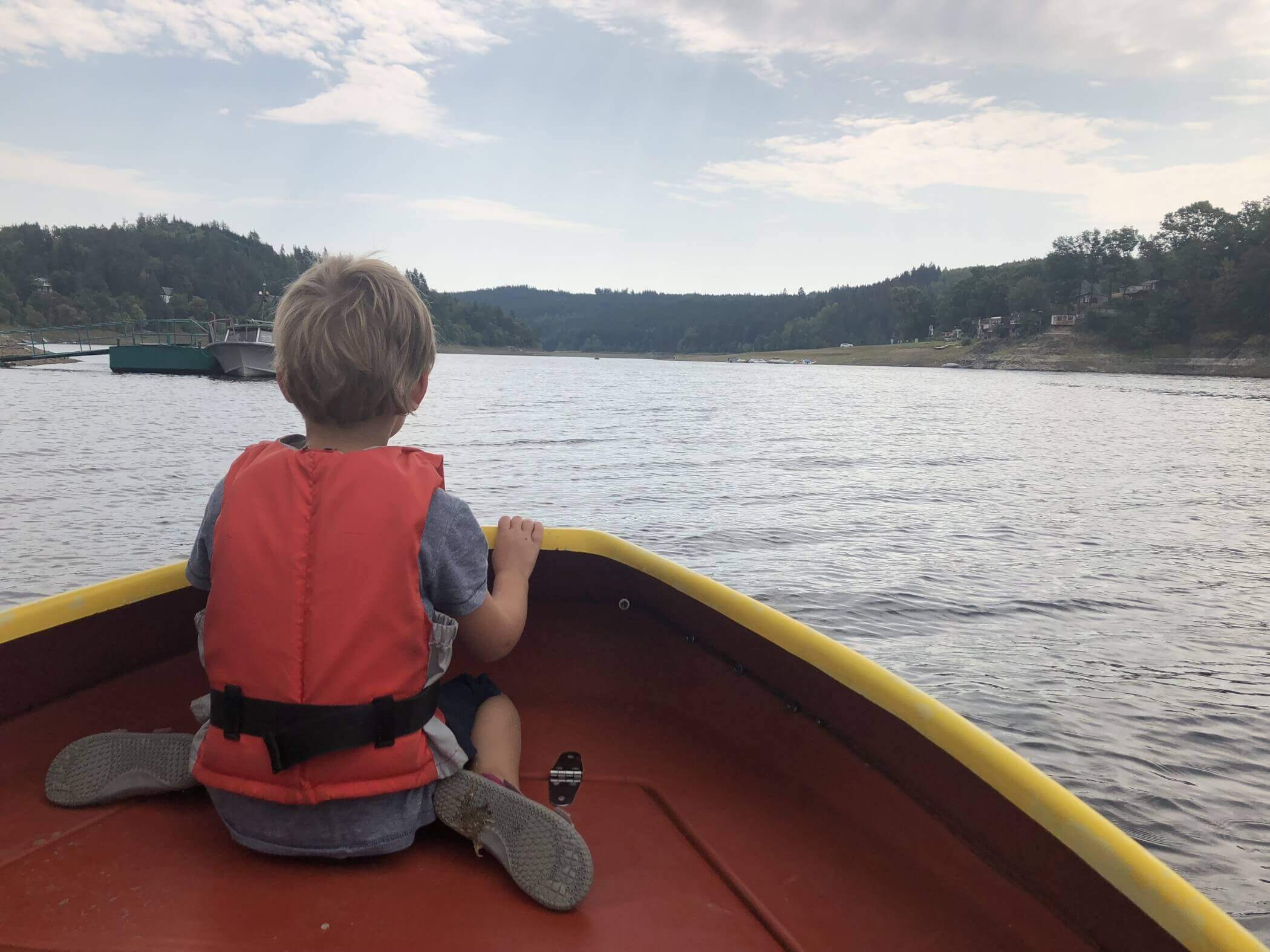 Kind auf Bootsbug blickt in die Ferne