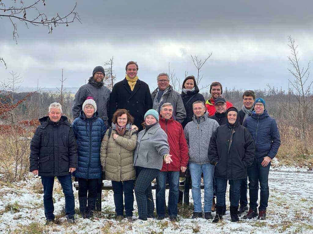 15 Personen des Gemeindekirchenrates vor winterlicher Landschaft stehend.